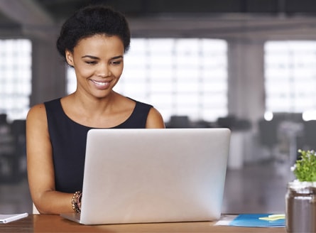 stock photo of a woman smiling at a laptop