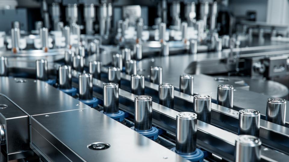 Industrial scene showing a high-tech factory assembly line. Lithium-ion batteries in the form of shiny metallic cylinders are lined up uniformly, conveying a clean, efficient, and modern feel. 