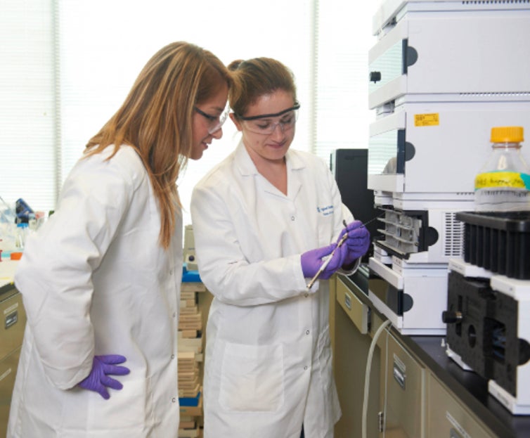 Two scientists inspecting Agilent column